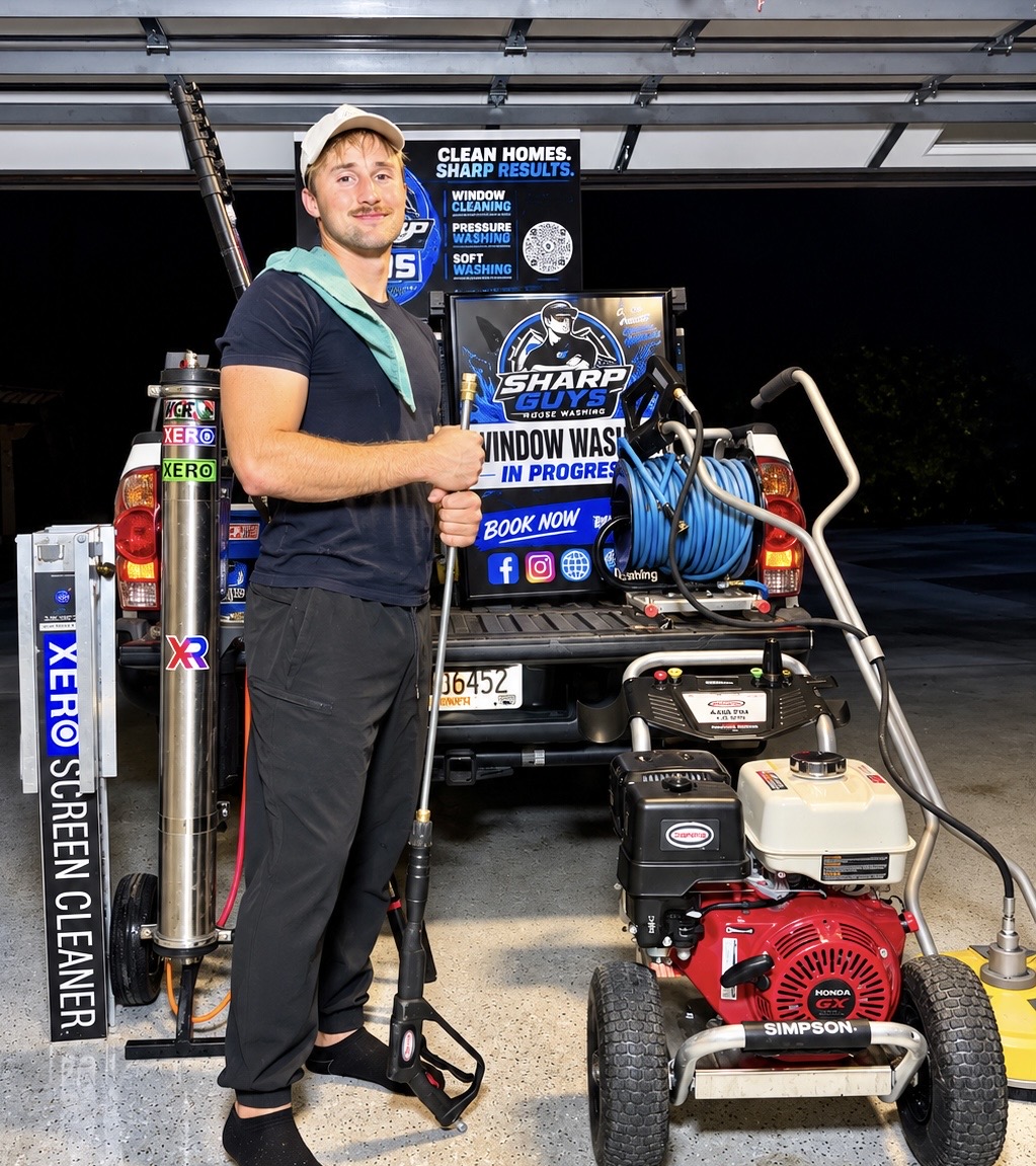 Nik, owner of Sharp Guys House Washing, standing with his cleaning equipment