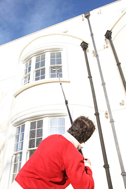 Cleaning exterior windows on a home's upper story